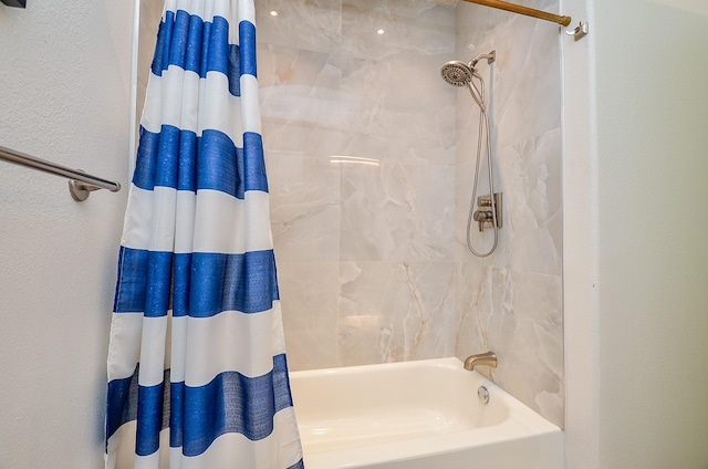 bathroom with shower / bath combination with curtain and a textured wall