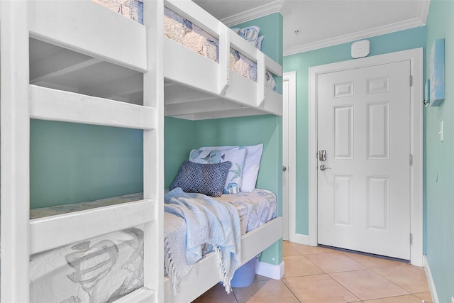 bedroom featuring light tile patterned floors, baseboards, and crown molding