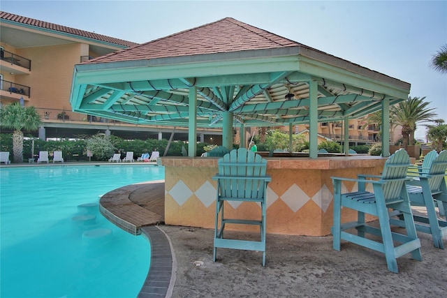 view of pool with an outdoor bar and a gazebo