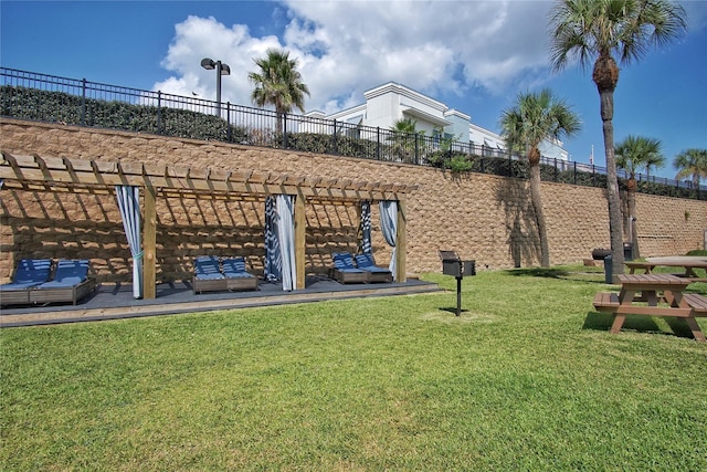 view of community with a lawn, fence, and a pergola