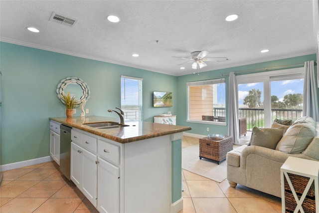 kitchen with visible vents, white cabinets, open floor plan, a sink, and stainless steel dishwasher