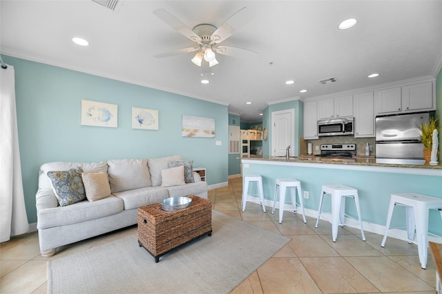 living room featuring light tile patterned floors, visible vents, and ornamental molding