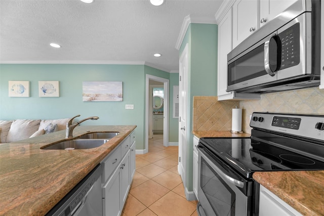 kitchen featuring a sink, white cabinetry, appliances with stainless steel finishes, backsplash, and crown molding