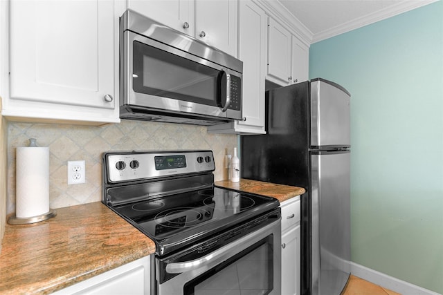 kitchen with stainless steel appliances, ornamental molding, white cabinetry, and tasteful backsplash