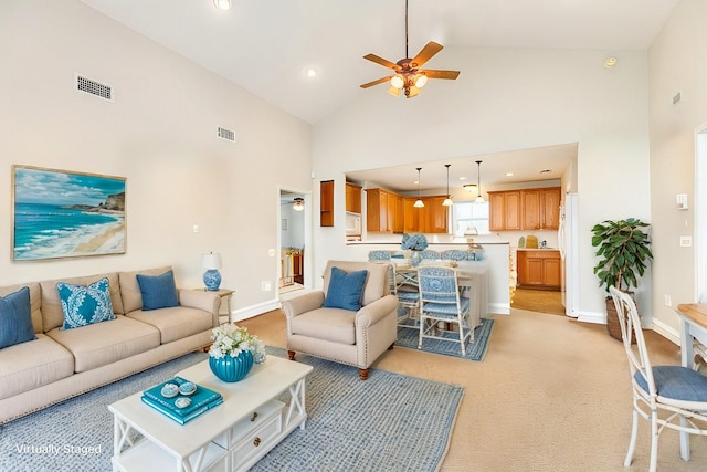 living area featuring ceiling fan, high vaulted ceiling, visible vents, and baseboards