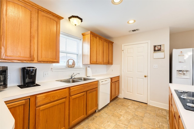 kitchen featuring light countertops, white appliances, a sink, and visible vents