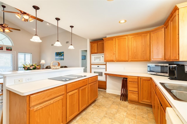 kitchen with white appliances, brown cabinetry, hanging light fixtures, light countertops, and a sink