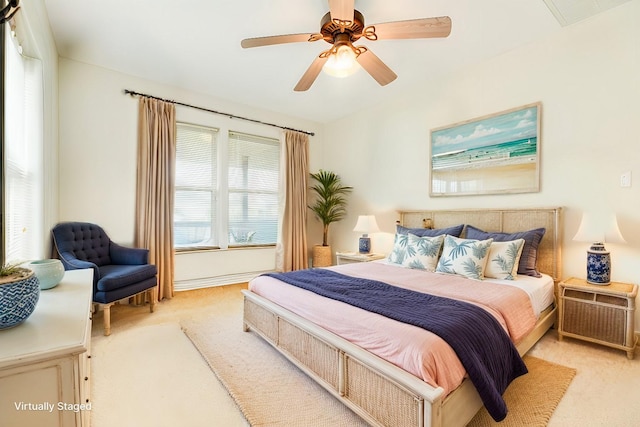 bedroom with light carpet, visible vents, and a ceiling fan