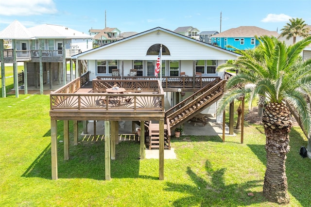 rear view of property featuring a residential view, stairway, a lawn, and a wooden deck