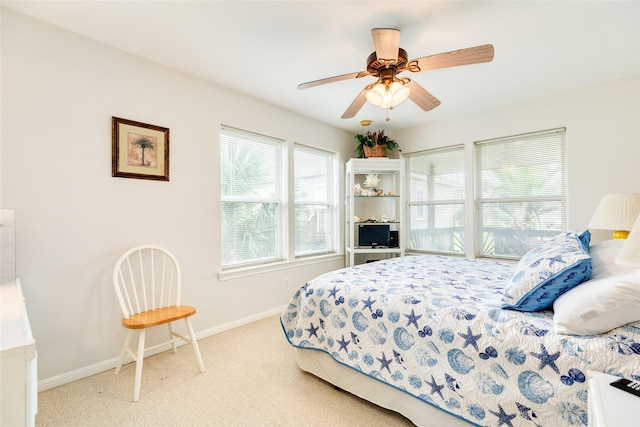 bedroom featuring a ceiling fan, light carpet, and baseboards