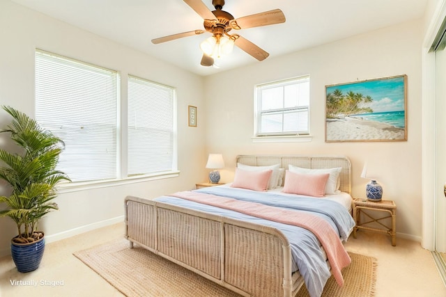 bedroom with ceiling fan, baseboards, and light colored carpet