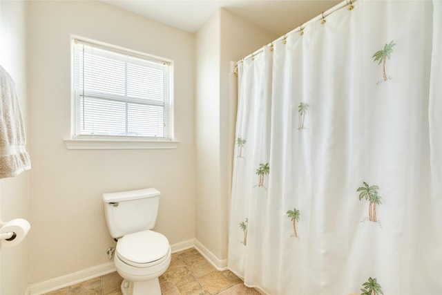 bathroom with toilet and baseboards