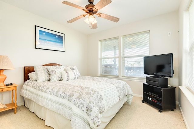 bedroom with baseboards, a ceiling fan, and light colored carpet