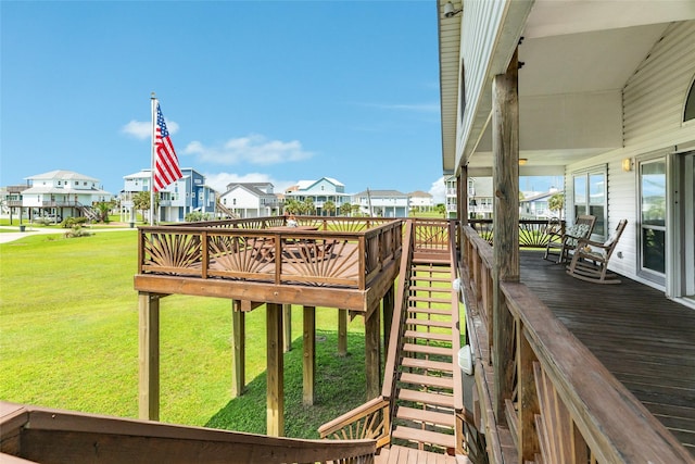 wooden terrace with a residential view and a yard