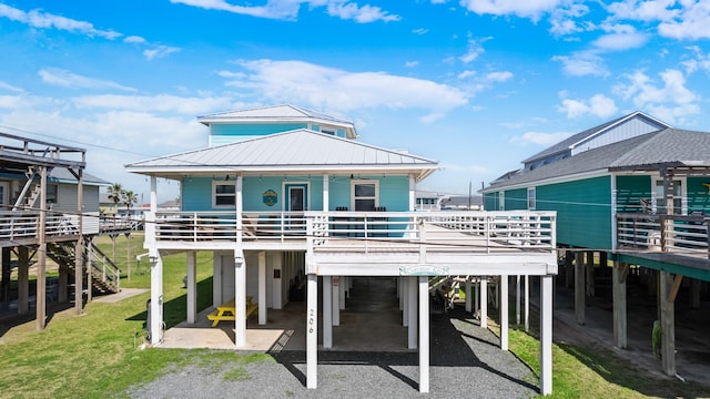 rear view of house with driveway, a carport, and a yard