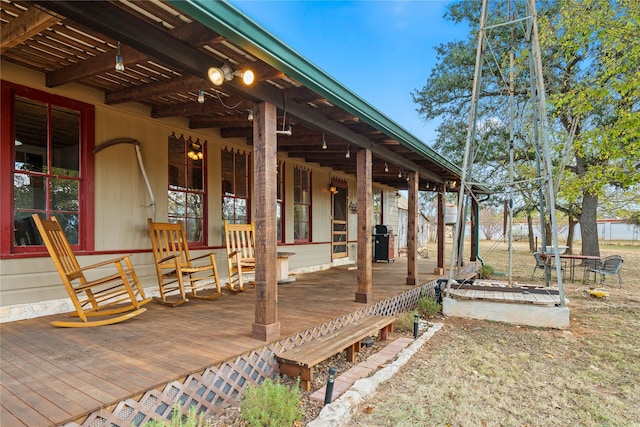 wooden deck with a porch and area for grilling