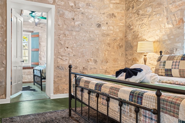 bedroom featuring finished concrete flooring and baseboards