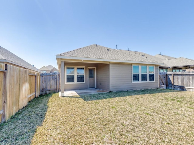 rear view of property with a yard, a fenced backyard, a patio, and roof with shingles