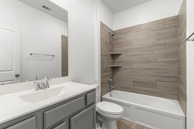 full bath with shower / bath combination, visible vents, toilet, vanity, and wood finished floors