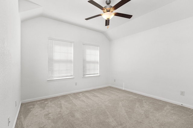 unfurnished room with lofted ceiling, light carpet, baseboards, and a ceiling fan