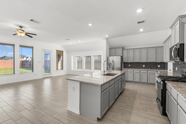 kitchen with visible vents, a kitchen island with sink, appliances with stainless steel finishes, and open floor plan