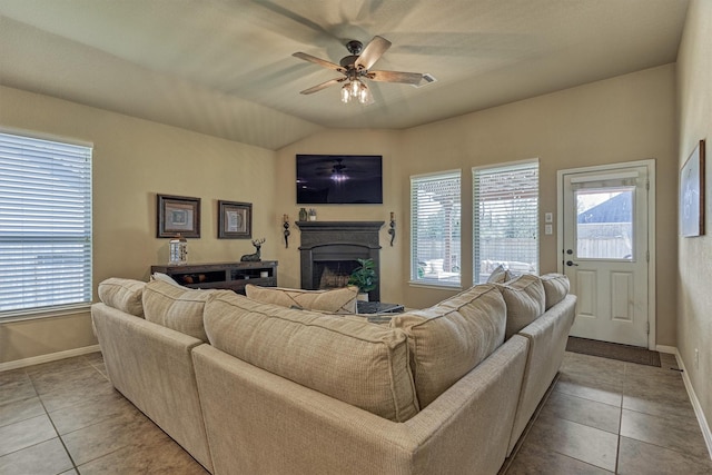 living area with plenty of natural light, light tile patterned flooring, a fireplace, and a ceiling fan