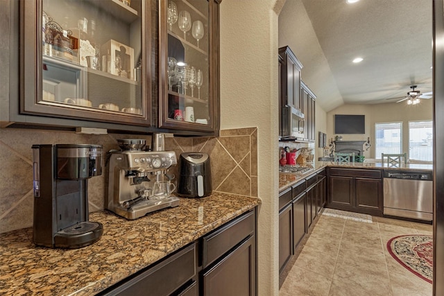 bar with lofted ceiling, ceiling fan, appliances with stainless steel finishes, backsplash, and light tile patterned flooring