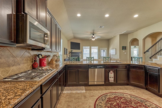 kitchen featuring stainless steel appliances, a sink, a ceiling fan, visible vents, and decorative backsplash