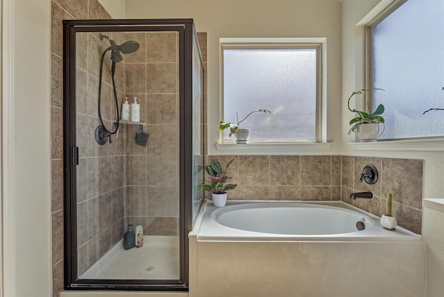 bathroom with a stall shower and a bath