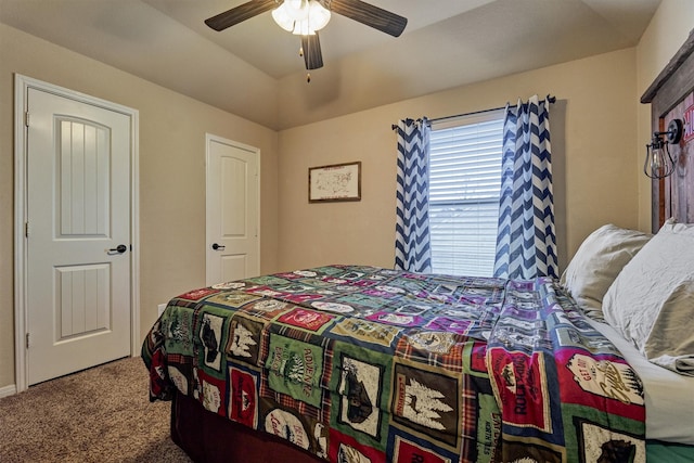 carpeted bedroom with a tray ceiling and ceiling fan