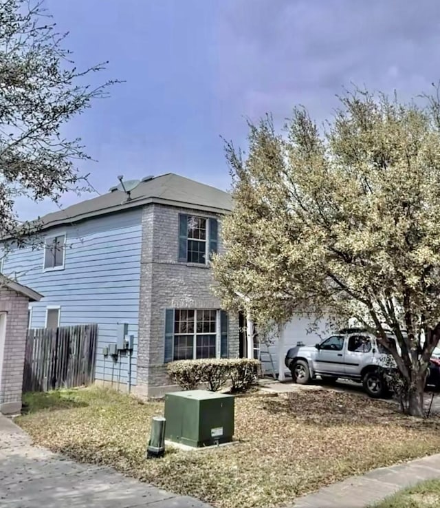 view of property exterior featuring a garage, concrete driveway, and fence