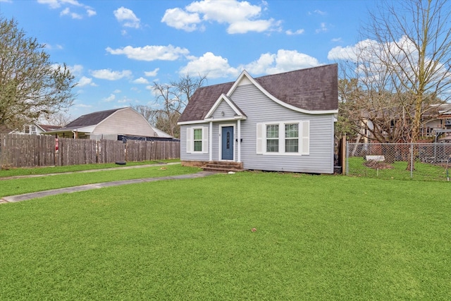 view of front of property with a shingled roof, a front yard, and fence