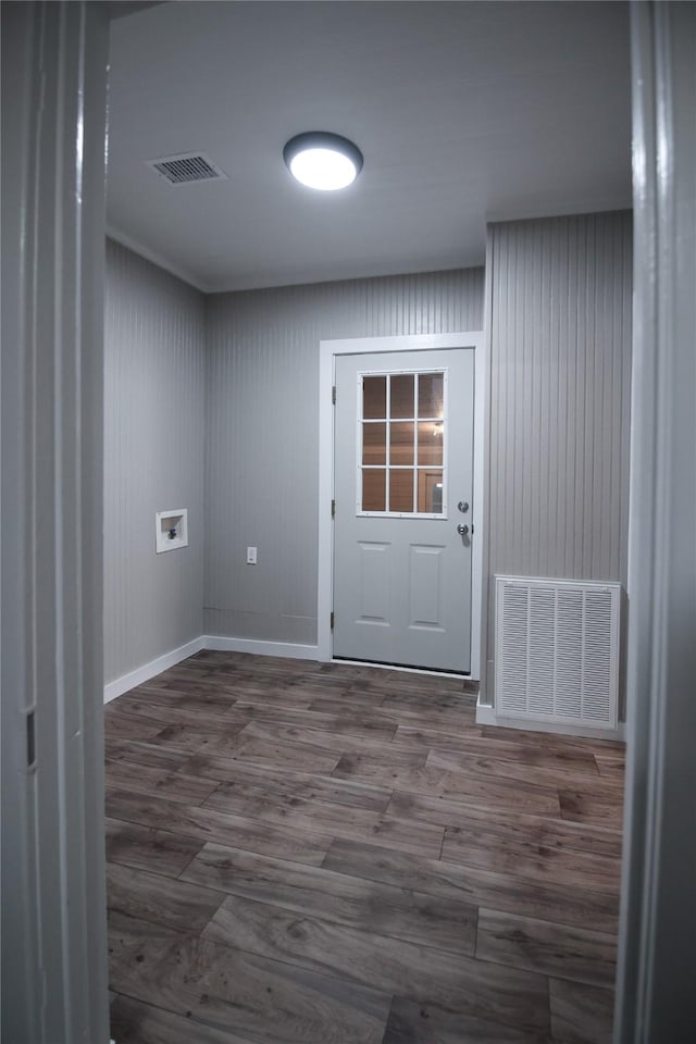 doorway featuring baseboards, visible vents, and wood finished floors