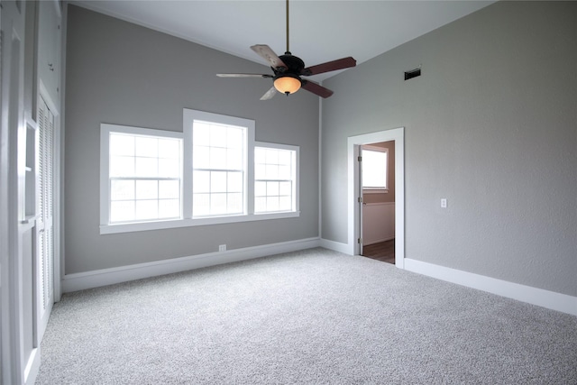 carpeted spare room featuring high vaulted ceiling, a ceiling fan, visible vents, and baseboards