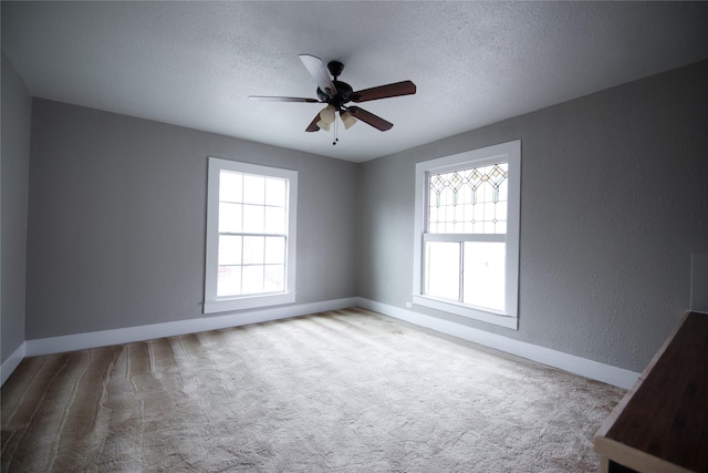 spare room with light carpet, a textured wall, a textured ceiling, and ceiling fan