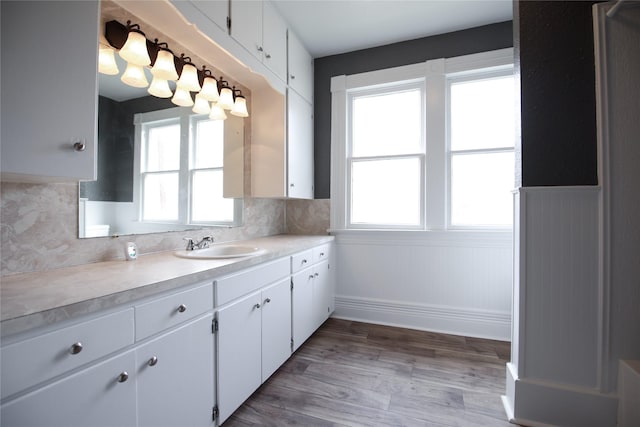 kitchen with light countertops, wainscoting, and white cabinetry