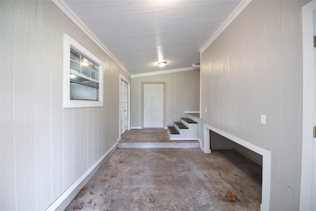 doorway to outside featuring unfinished concrete floors and crown molding