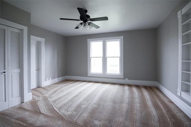 unfurnished bedroom with ceiling fan, baseboards, a closet, and light colored carpet