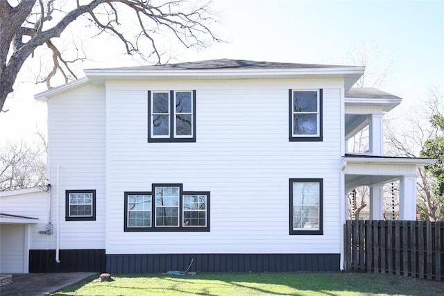 view of home's exterior with fence and a yard