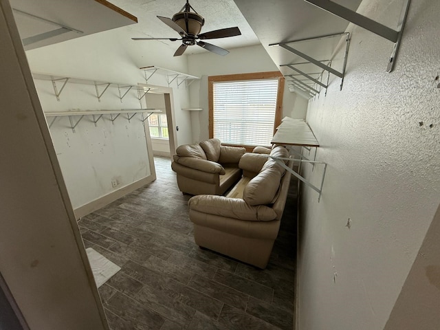 living area featuring dark wood-style floors, a ceiling fan, attic access, and baseboards