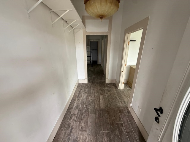 hall featuring dark wood-style flooring and baseboards