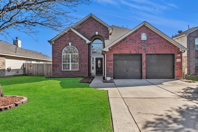 traditional home with a garage, concrete driveway, fence, a front yard, and brick siding