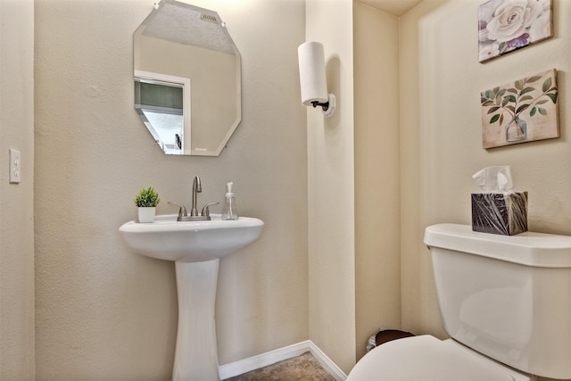 bathroom featuring toilet and baseboards