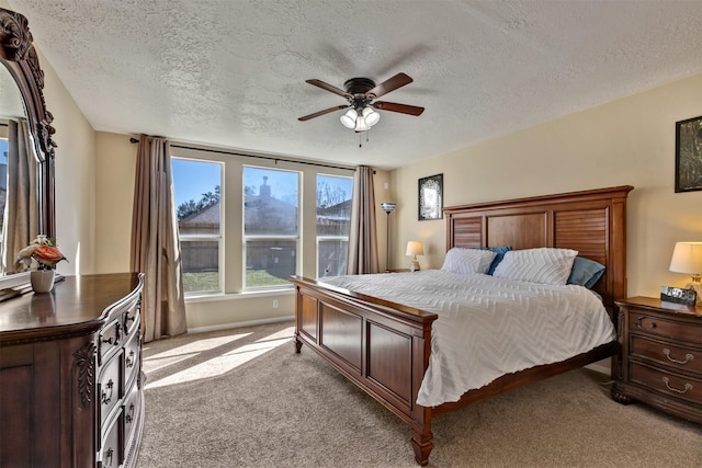 bedroom featuring a ceiling fan, light colored carpet, and a textured ceiling