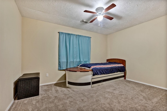 carpeted bedroom with baseboards, a ceiling fan, a textured ceiling, and visible vents