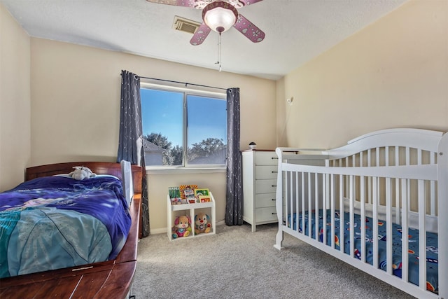 bedroom featuring baseboards, visible vents, ceiling fan, carpet, and a textured ceiling