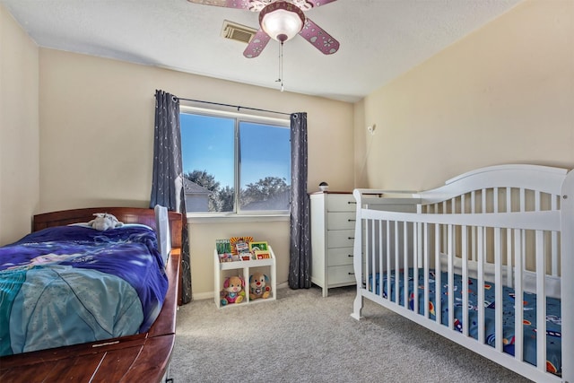 carpeted bedroom featuring visible vents and a ceiling fan