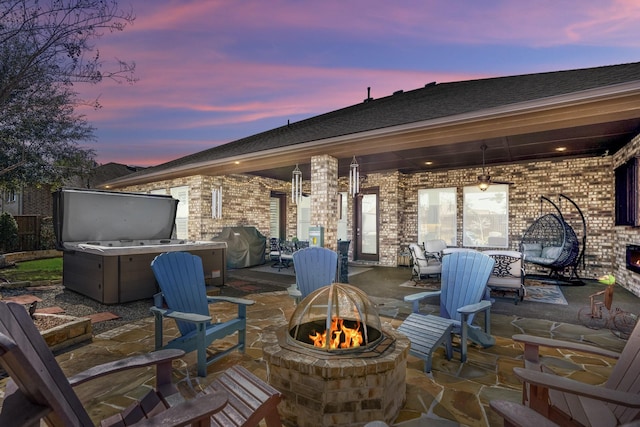 view of patio with a hot tub, an outdoor fire pit, and grilling area