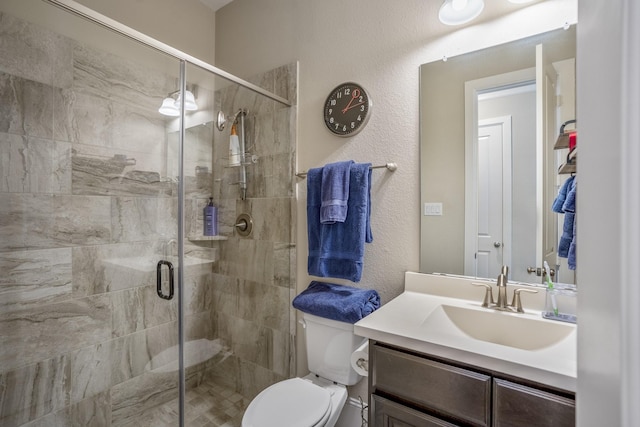 full bathroom with a textured wall, vanity, a shower stall, and toilet