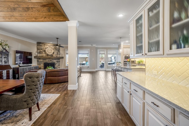 kitchen featuring light stone counters, open floor plan, white cabinets, and pendant lighting